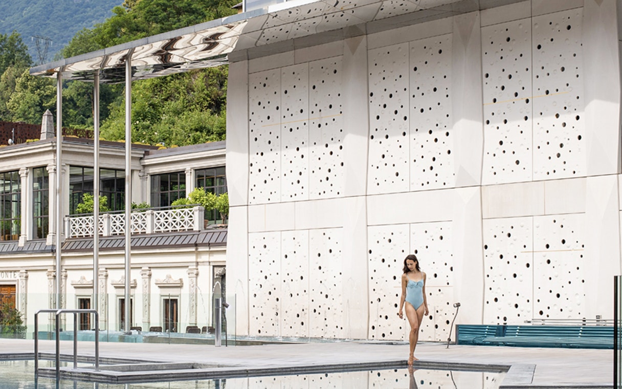 Woman walking by the pool at QC Terme San Pellegrino Spa, Italy.