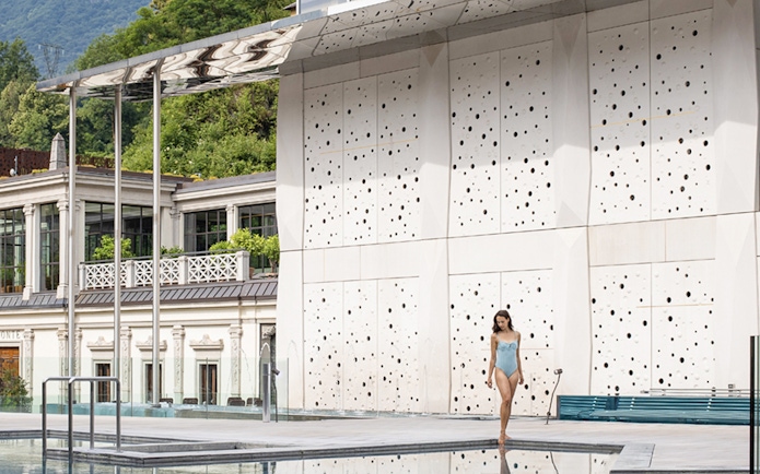 Woman walking by the pool at QC Terme San Pellegrino Spa, Italy.