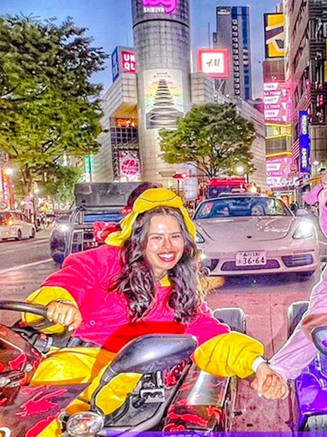 Tourists in themed costumes driving go-karts in Tokyo's vibrant city streets.