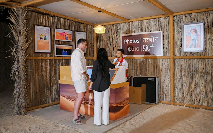 Photo booth at desert safari with visitors interacting with staff.