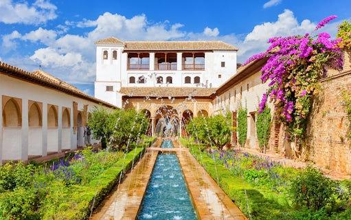 Alhambra's Generalife gardens with fountains and vibrant flowers in Granada, Spain.