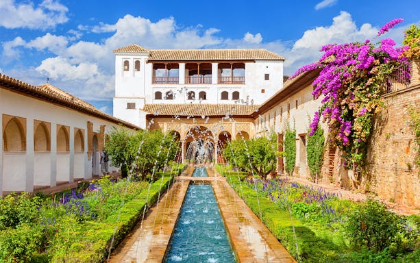 Alhambra's Generalife gardens with fountains and vibrant flowers in Granada, Spain.