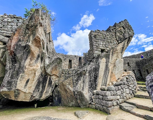 Temple of Condor stone structure at Machu Picchu with surrounding ancient ruins.