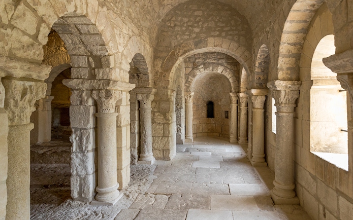 Stone arches and columns inside Montmajour Abbey, France.