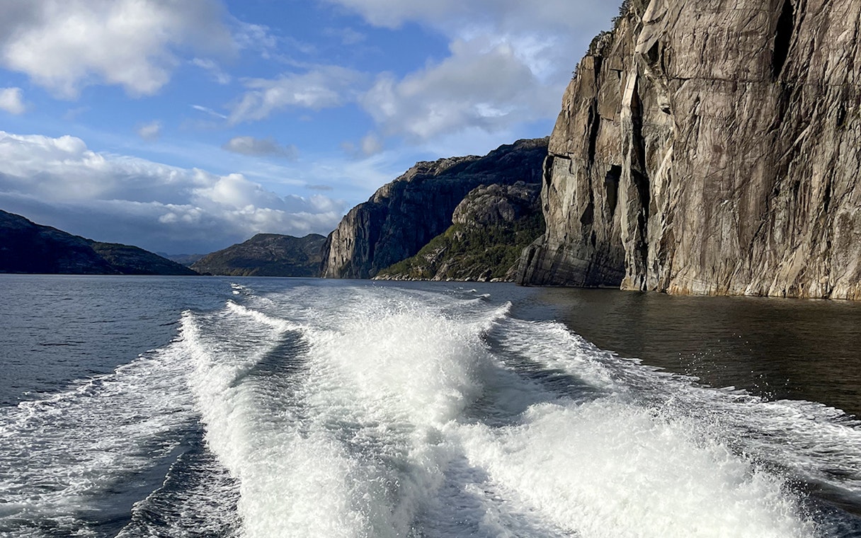 Fjordcruise view of Lysefjord cliffs and water trail near Preikestolen, Norway.