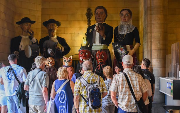 Visitors observing giant figures inside Cathedral of Palma.