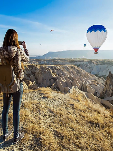 Guest photographing hot air balloons over Gerome Valley, Cappadocia.