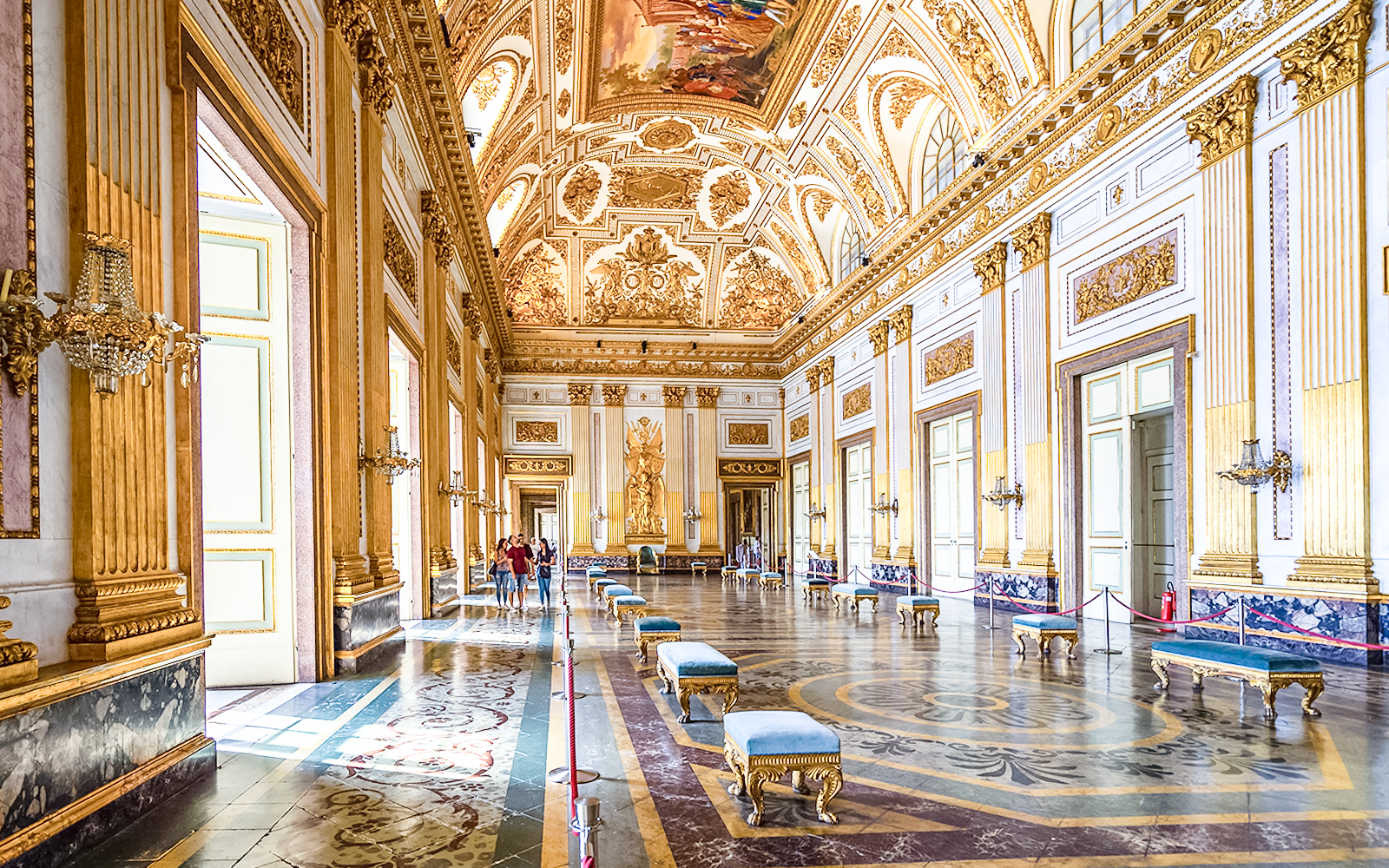 Royal Palace of Caserta interior with ornate ceiling and gilded walls.