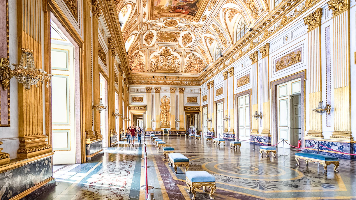 Royal Palace of Caserta interior with ornate ceiling and gilded walls.