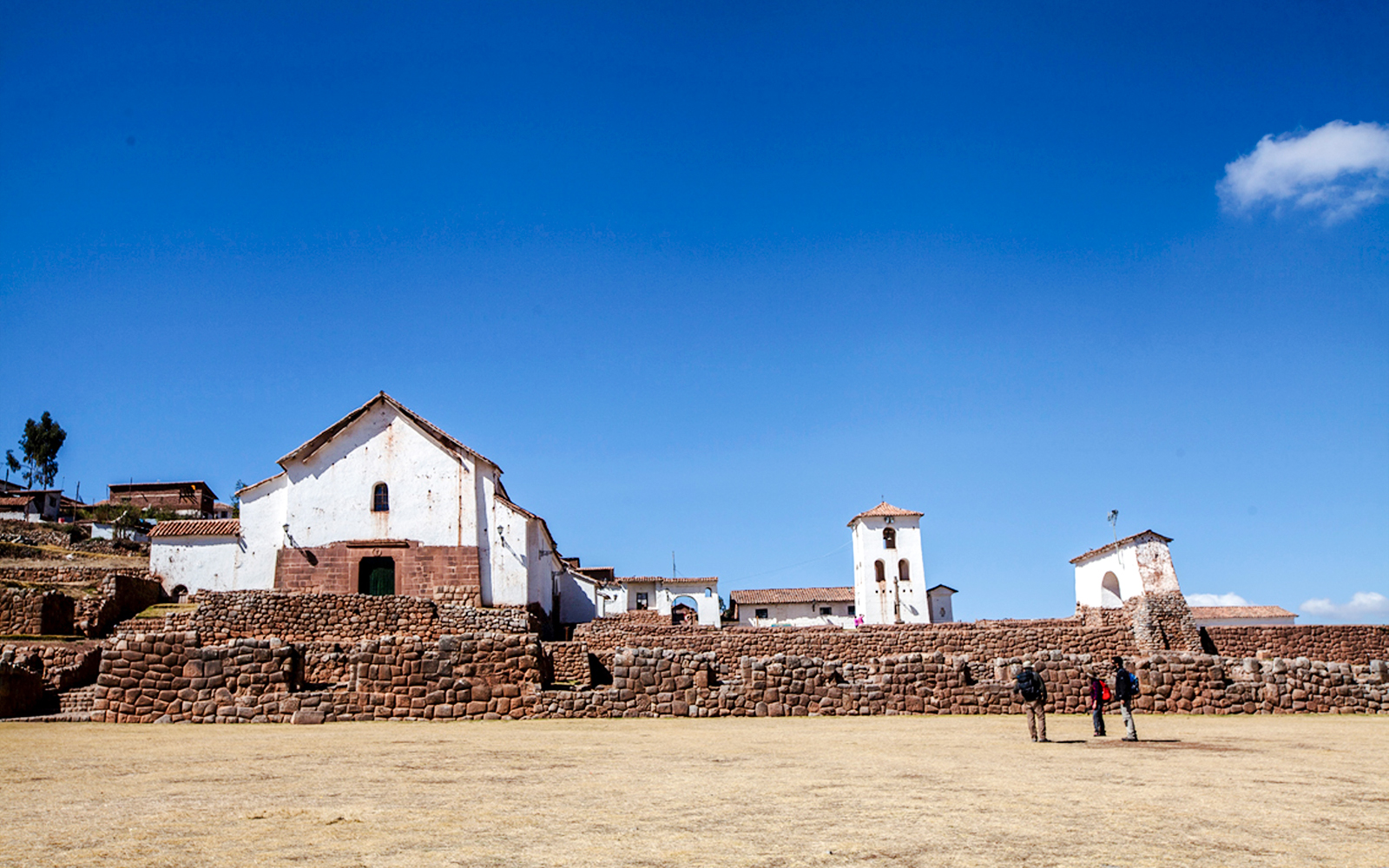 Colonial Church of Chinchero with stone terraces under a clear blue sky in Chinchero, Peru.