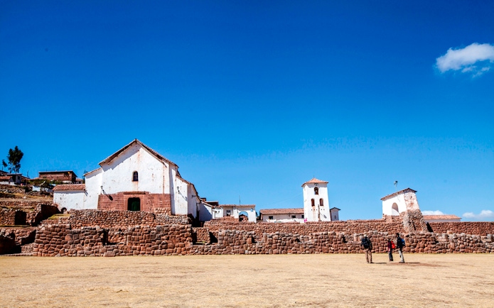 Colonial Church of Chinchero with stone terraces under a clear blue sky in Chinchero, Peru.
