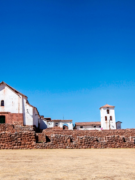 Colonial Church of Chinchero with stone terraces under a clear blue sky in Chinchero, Peru.