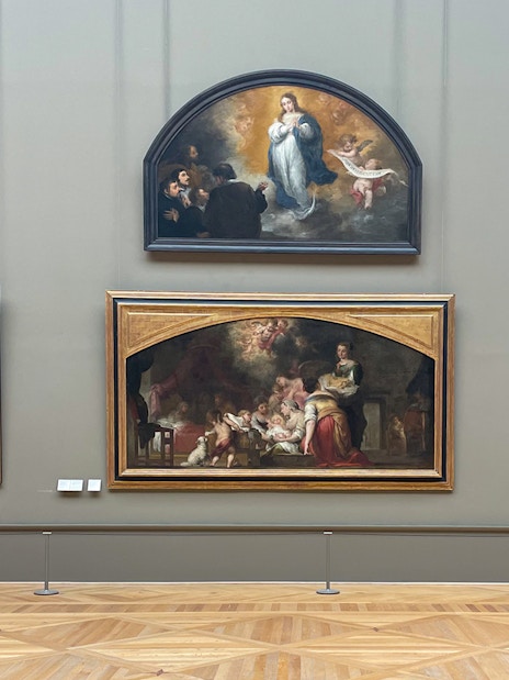 Louvre Museum visitors viewing religious paintings in a gallery.