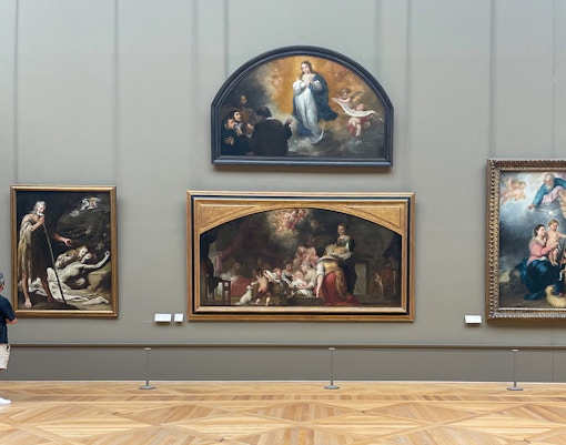 Visitors admiring the famous Louvre Museum paintings in Paris, France