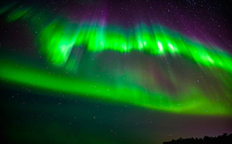 Northern Lights over snowy landscape in Rovaniemi, Finland.