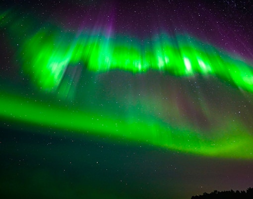 northern lights in the sky over tromso city