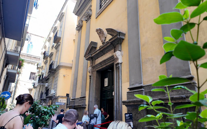Entrance to Sansevero Chapel with visitors in Naples.