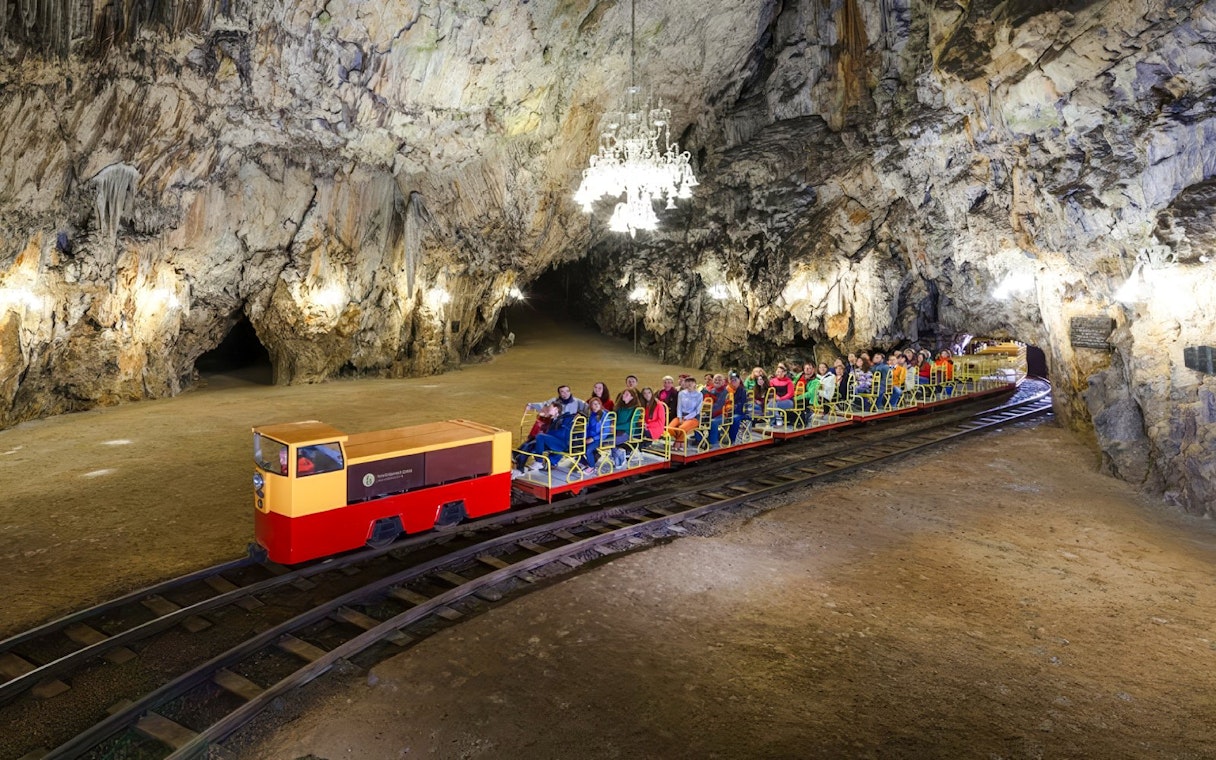 Tourists riding a toy train inside Postojna Cave, Slovenia.