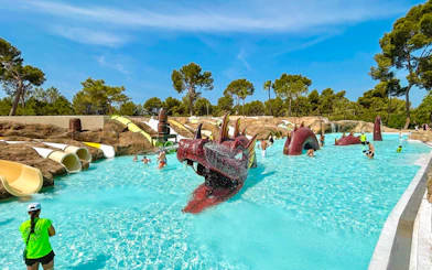 Visitors enjoying the dragon-themed pool at Aqualand El Arenal with slides and water features.