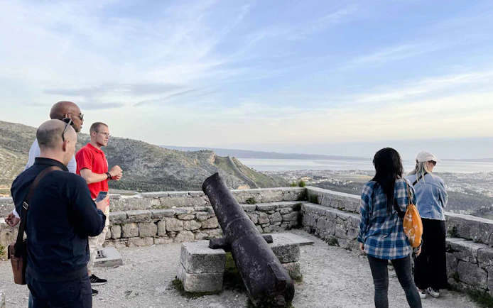 Tourists viewing Split from a historic fort with a cannon, part of the Split Panoramic Bus Tour.