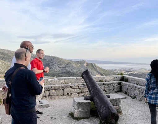 Tourists viewing Split from a historic fort with a cannon, part of the Split Panoramic Bus Tour.