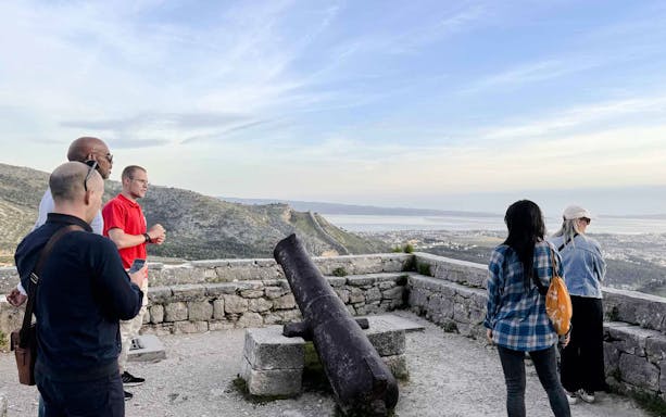 Tourists viewing Split from a historic fort with a cannon, part of the Split Panoramic Bus Tour.