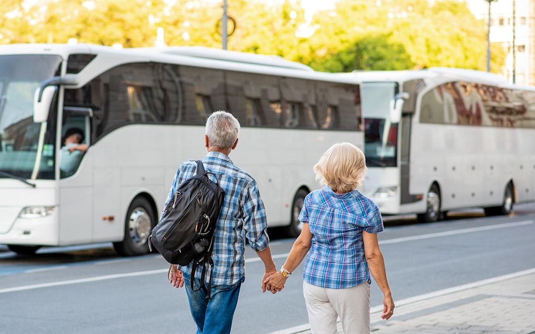 Tourists boarding a bus for Transporte a Puy du Fou Parque from Toledo.
