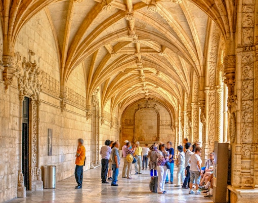 Cloister of the Jeronimos Monastery in Lisbon, Portugal, showcasing intricate Gothic architecture.