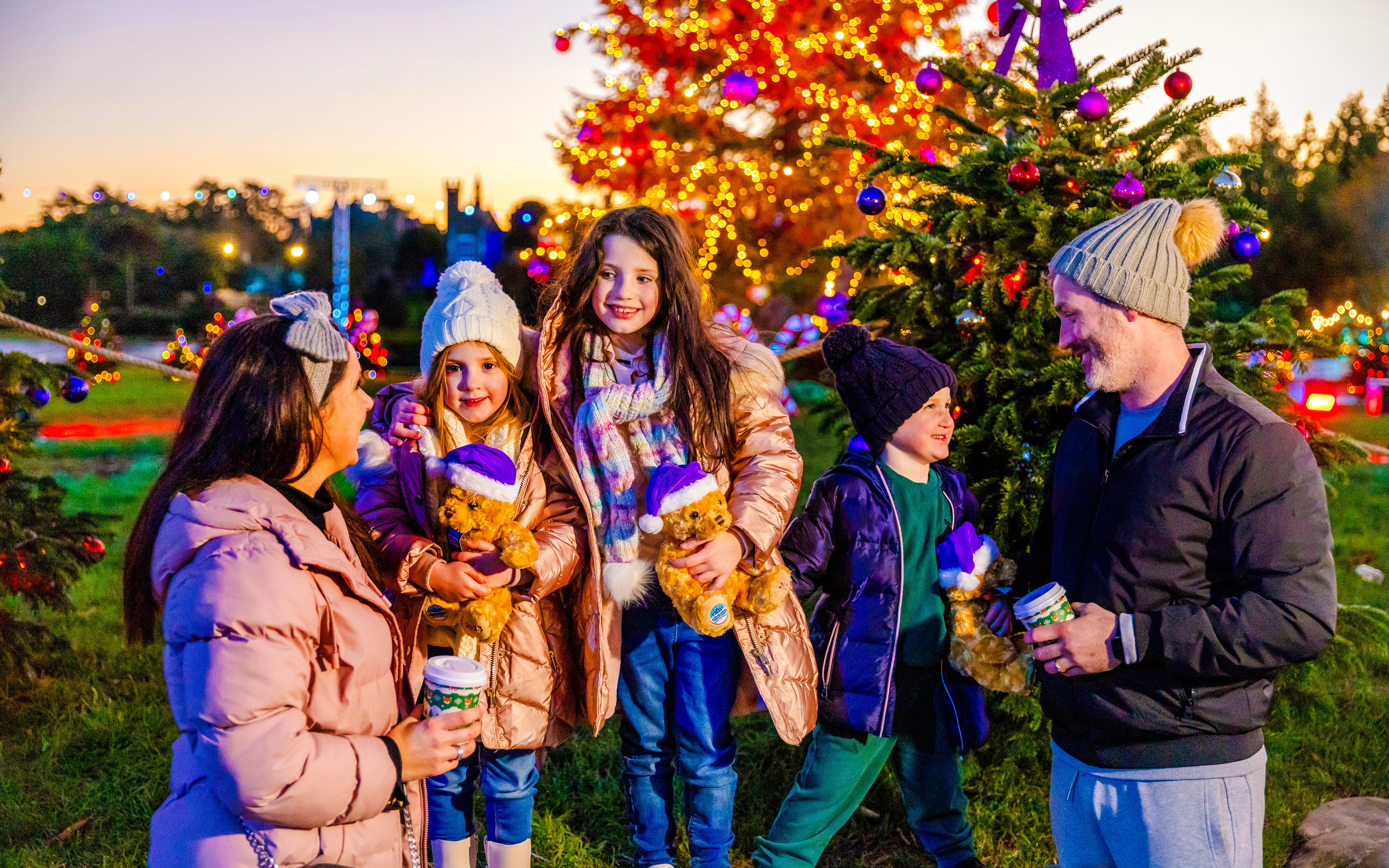 Guests enjoying Christmas festivities at Alton Towers with decorated trees and lights.