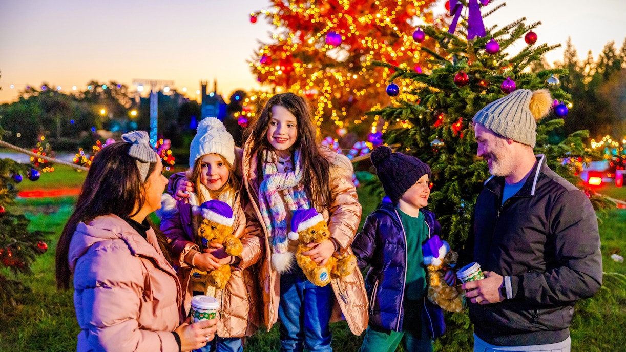 Guests enjoying Christmas festivities at Alton Towers with decorated trees and lights.