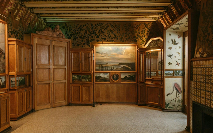 Casa Vicens main floor with ornate wooden cabinets and nature-themed murals.