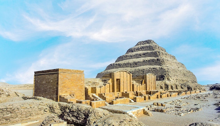 Pyramid of Djoser at Saqqara necropolis, Egypt, with surrounding ancient structures.