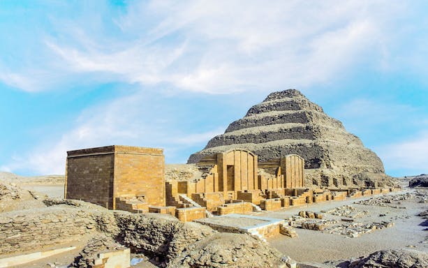 Pyramid of Djoser at Saqqara necropolis, Egypt, with surrounding ancient structures.