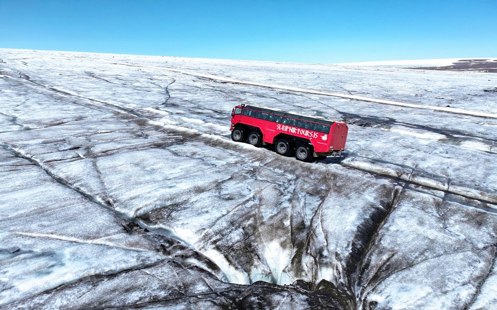 Red tour truck on Langjökull Glacier during Gullfoss tour in Iceland.