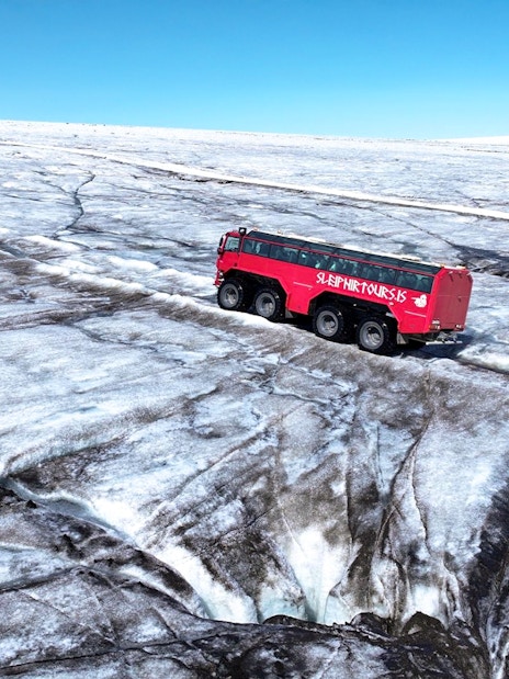 Red tour truck on Langjökull Glacier during Gullfoss tour in Iceland.