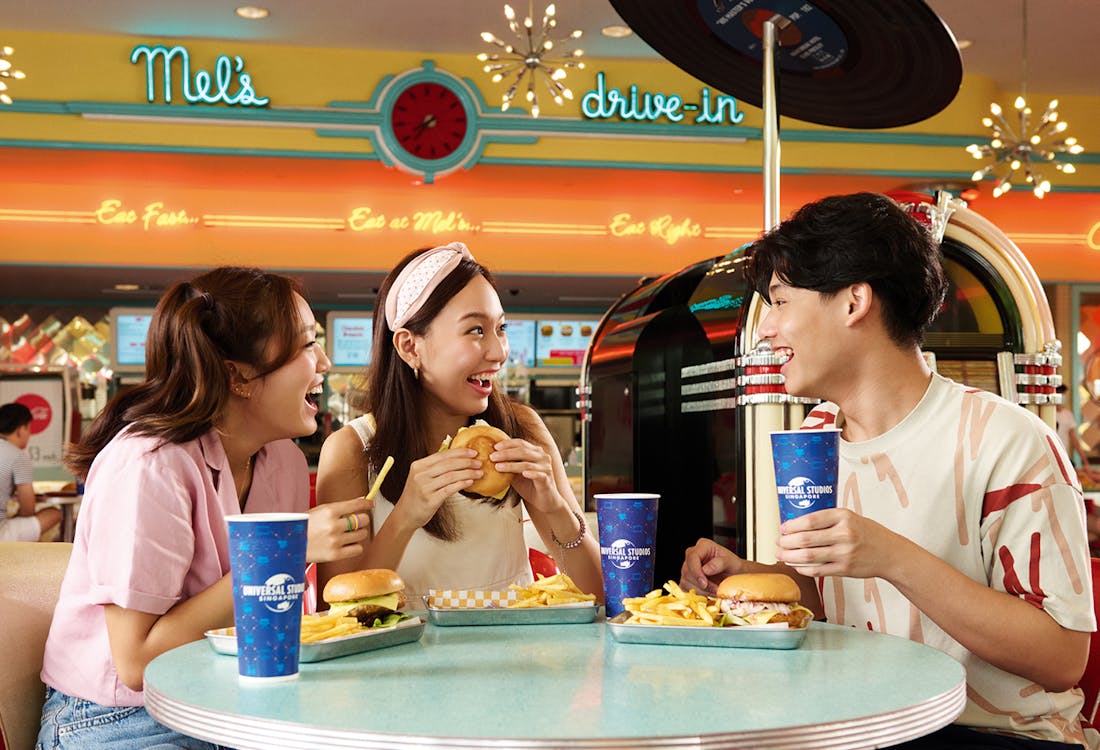 Mel's Dine-In retro diner at Universal Studios Singapore with classic cars parked outside.