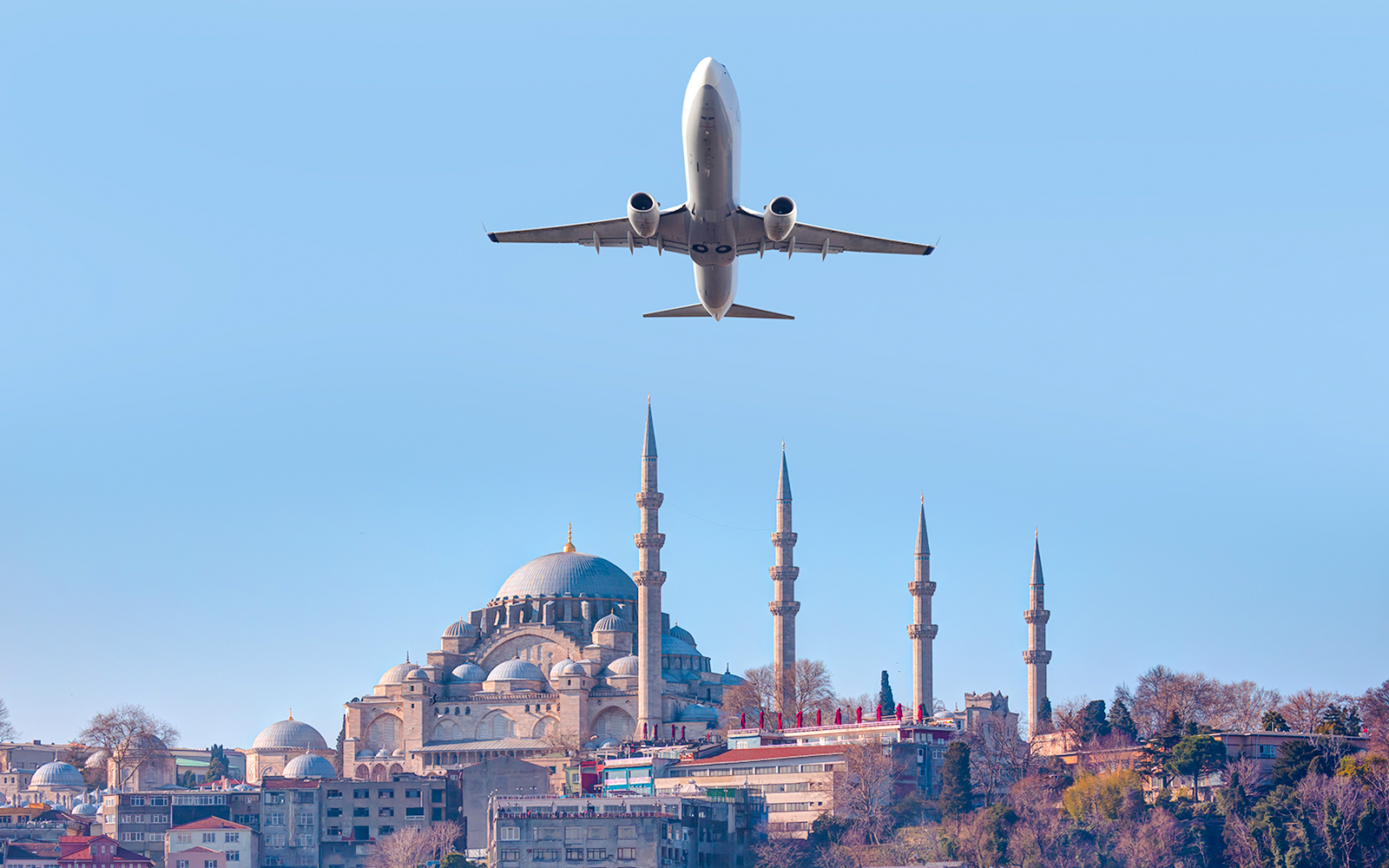 Airplane flying over Suleymaniye Mosque in Istanbul, Turkey.