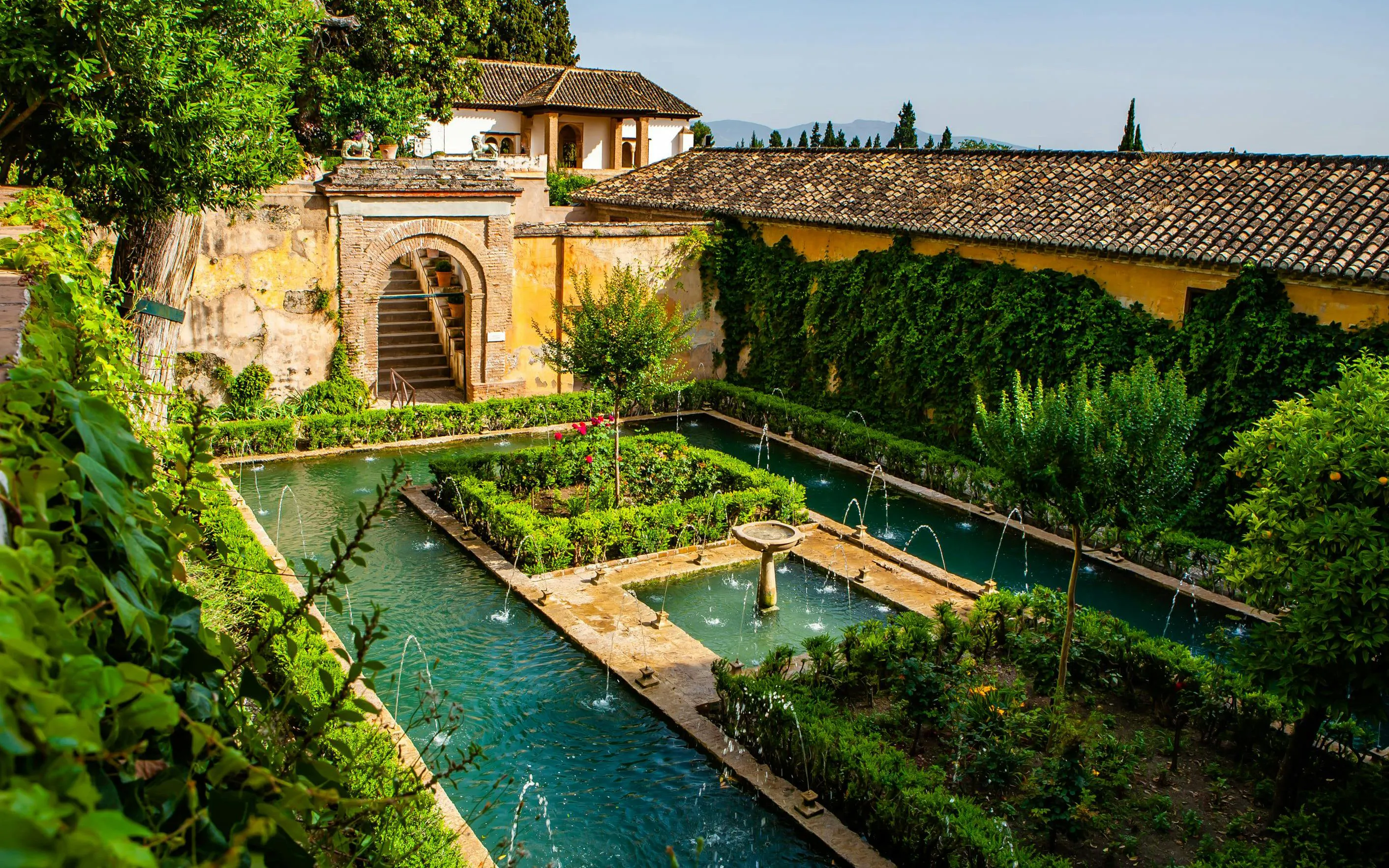 Patio de la Acequia with water channels and lush gardens in Generalife, Alhambra, Granada, Spain.