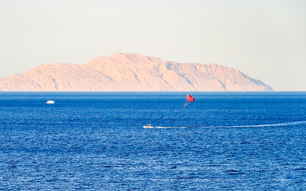 Parasailing over the Red Sea with Ras Mohammed National Park mountains in the background.