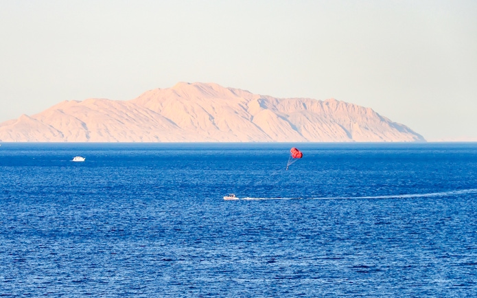 Parasailing over the Red Sea with Ras Mohammed National Park mountains in the background.