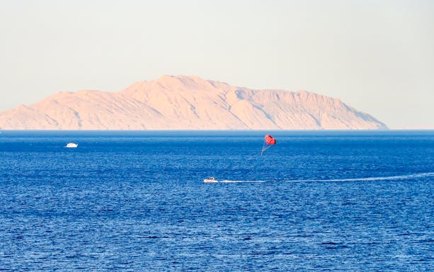 Parasailing over the Red Sea with Ras Mohammed National Park mountains in the background.