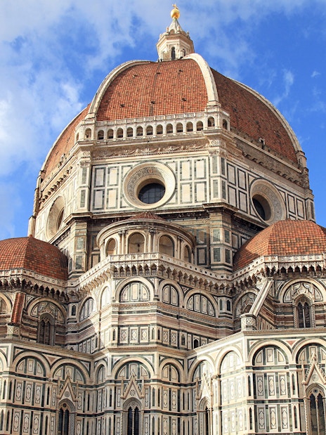 Florence Cathedral's red-tiled dome and marble facade under blue sky, part of Florence in a Day tour.