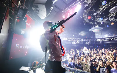 Performer in futuristic costume at WARP Shinjuku Nightclub with crowd cheering.
