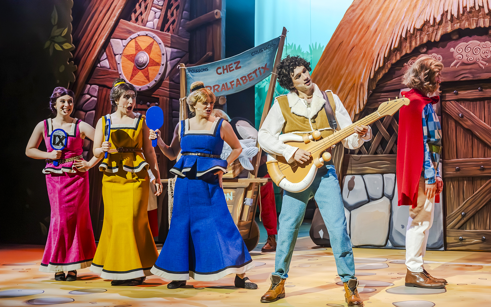 Performers in colorful costumes on stage at Parc Asterix, France.