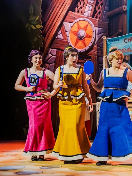 Performers in colorful costumes on stage at Parc Asterix, France.