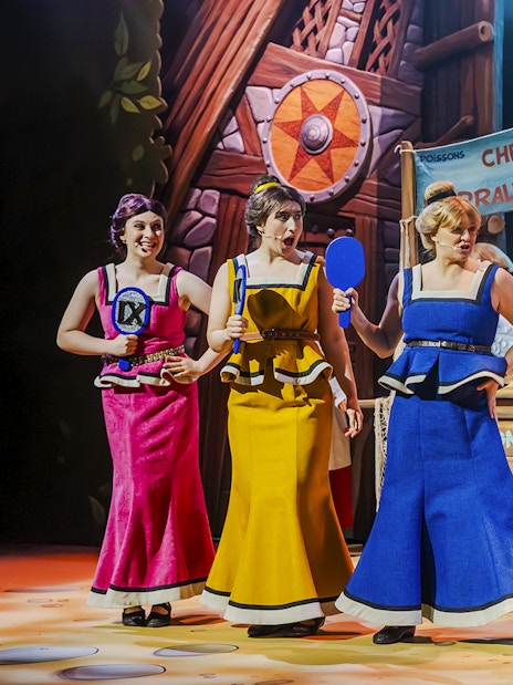 Performers in colorful costumes on stage at Parc Asterix, France.