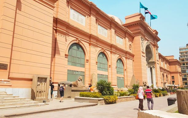 Egyptian Museum in Cairo with visitors exploring the exterior.