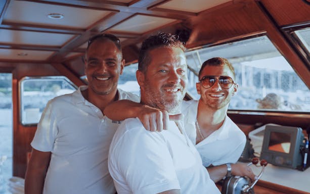 Boat crew smiling during 3-hour Tropea to Capo Vaticano trip with aperitif.