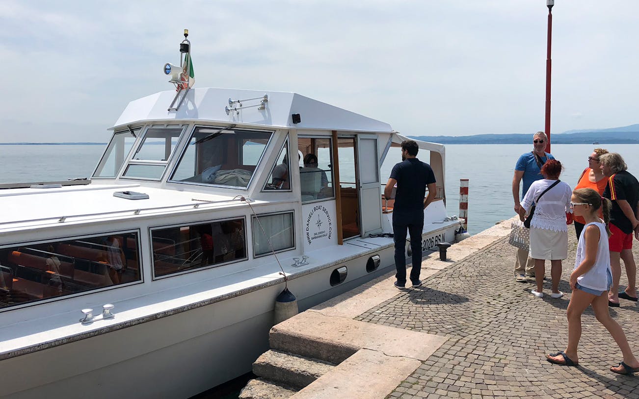 Tourists boarding a boat for a 4-hour cruise on Lake Garda to Sirmione.