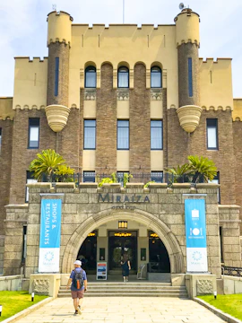 Entrance of Mirai Museum, featuring banners for shops and restaurants, related to the Illusion Museum and Magic Show.